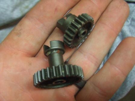 1996 Ford Bronco - Two metal gears are held in a hand, possibly for a toy or model vehicle.