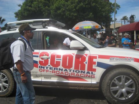 1996 Ford Bronco - A white SUV branded with SCORE International Off-Road Racing graphics is seen at an event.