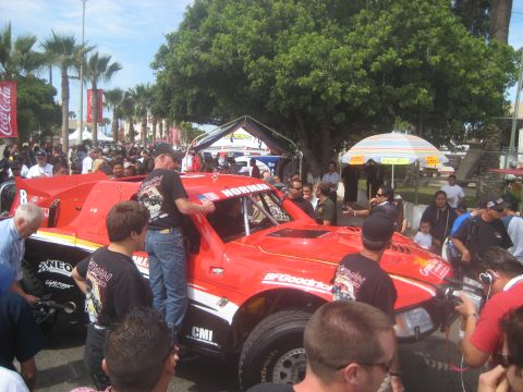 1996 Ford Bronco - A crowd gathers around a custom-built off-road racing truck during an event.