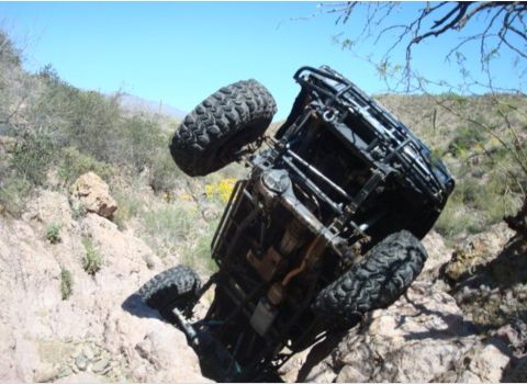 1986 Toyota Hilux - An off-road vehicle has overturned while navigating a steep, rocky incline.