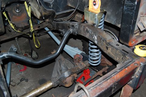 1994 Ford Bronco - Close-up view of a vehicle's frame, showing suspension parts, differential, and exhaust system during work.