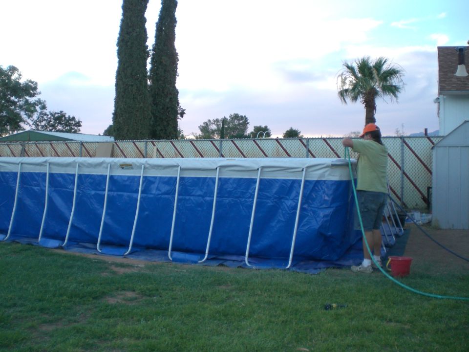 Above-ground pool being filled with a hose