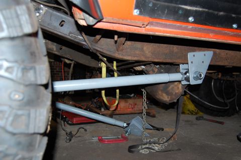 1994 Ford Bronco - Close-up view of the undercarriage of an orange vehicle, showing suspension and frame details.