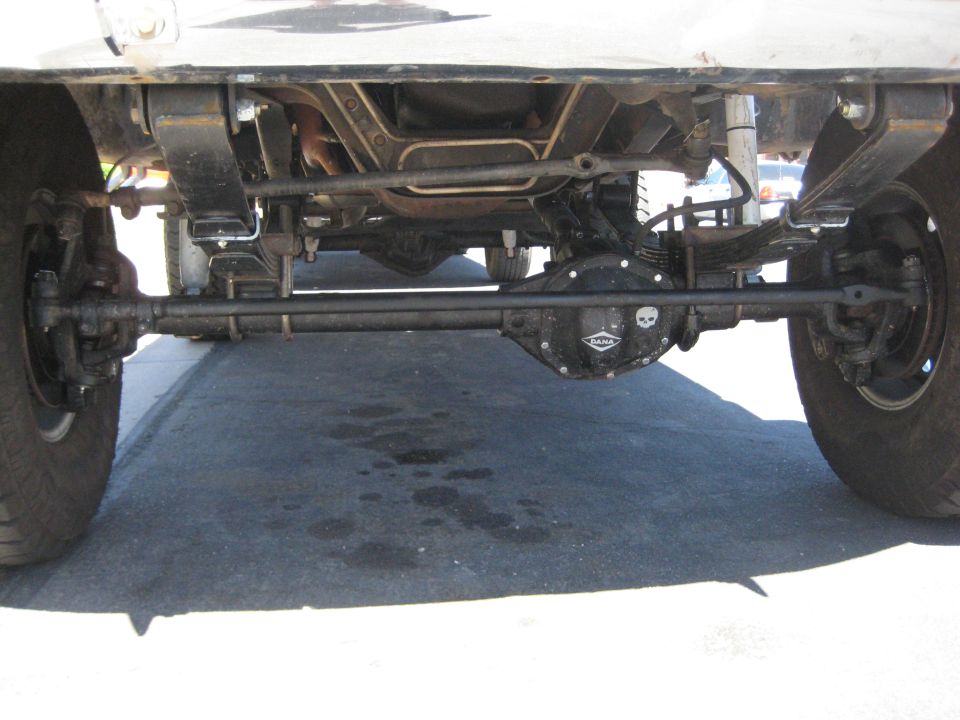 Undercarriage view of vehicle's steering and suspension components, including a differential cover with a skull emblem