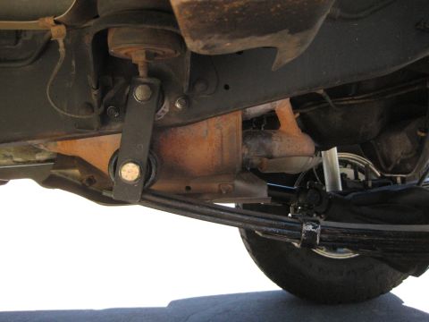 1996 Ford Bronco - Close-up view of the undercarriage of a vehicle, focusing on the suspension and exhaust system.
