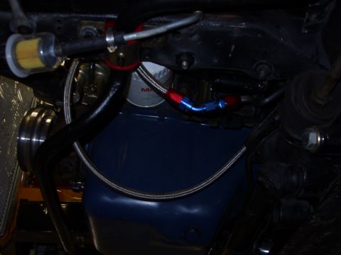 1978 Ford Mustang II - Braided hoses and fuel filter visible on the underside of a vehicle's power steering system.