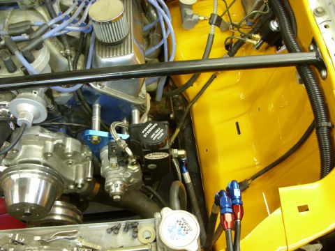 1978 Ford Mustang II - Detailed engine-bay shot of a V8 in a yellow-painted bay, showing a blue-painted block, blue plug wires, chrome breather, a JR Products pow…