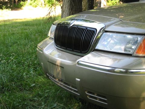 2000 Mercury Grand Marquis - Front view of a gold 2000 Mercury Grand Marquis, its distinctive grille and headlights.