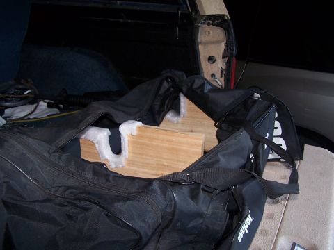 1986 Ford Bronco - A black duffel bag containing wooden supports is visible in the cargo area of a vehicle.