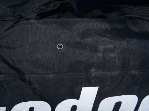 1986 Ford Bronco - A close-up view of a black gear bag, showing a metal snap and partial white lettering, possibly from a vehicle accessory.