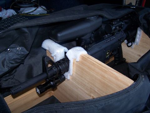 1986 Ford Bronco - A paintball marker, resembling a rifle, is packed in a soft case with wooden supports.