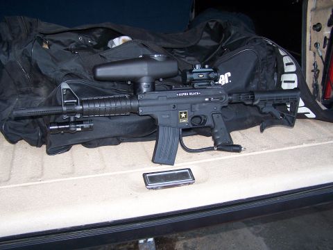 1986 Ford Bronco - A tactical-style paintball gun is placed on a bag inside a vehicle.