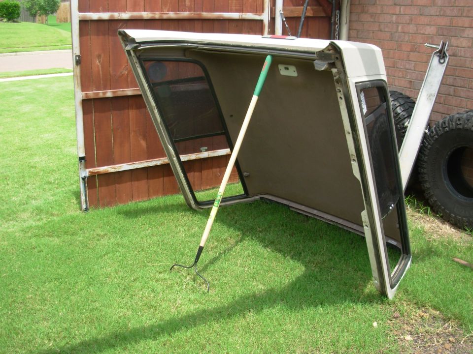 There's a common misconception that fiberglass will sag, bend, or warp if it's not stored just so.  It won't.  If it did, Corvette bodies & Bronco camper shells ('92-96 F4TB9850200A??) would all have melted into heaps by now, but they obviously don't.  So as long as the rubber seals aren't being cut or torn, any position is fine.

Just avoid touching the headliner (F4TZ9851942AAK).