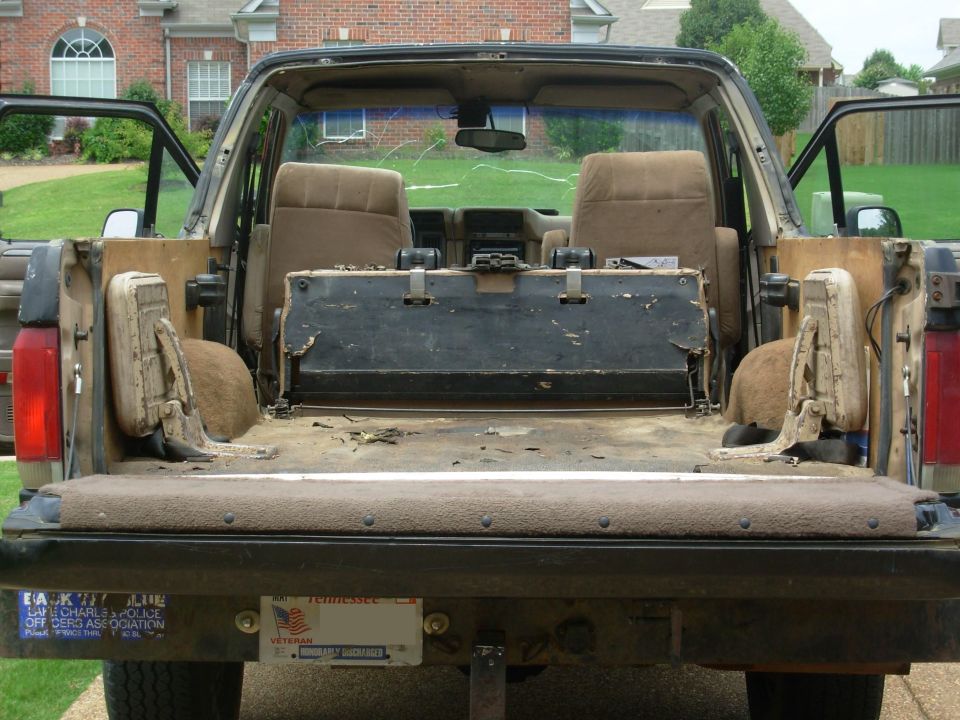 Muddy interior and cargo area of an open-top Bronco from rear