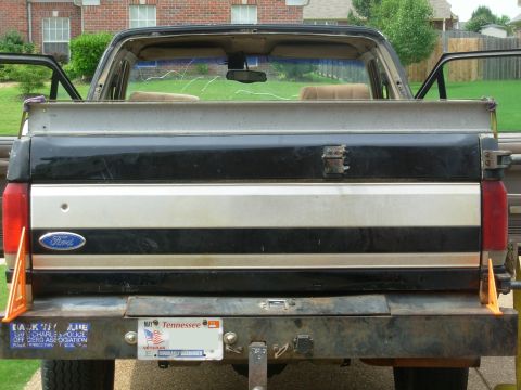 1983 Ford Bronco - I laid the long beam across the bedrails & put my heaviest ratchet strap over it. The strap is just tight enough to stay in place, and the…