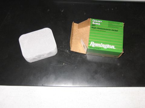 2001 Ford F-150 - Remington Golden Saber HPJ cartridges in a green box with a gray object nearby.