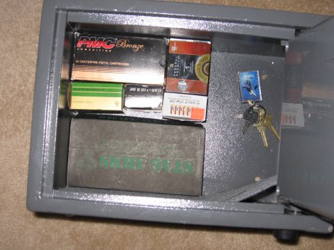 2001 Ford F-150 - A collection of ammunition boxes and keys are visible inside an open gray safe.