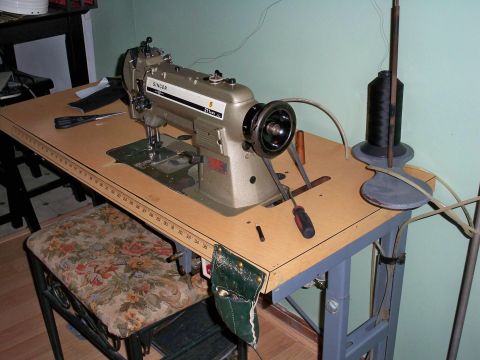 1995 Ford Probe - A sewing machine sits on a wooden table next to a spool of thread and a pair of scissors.