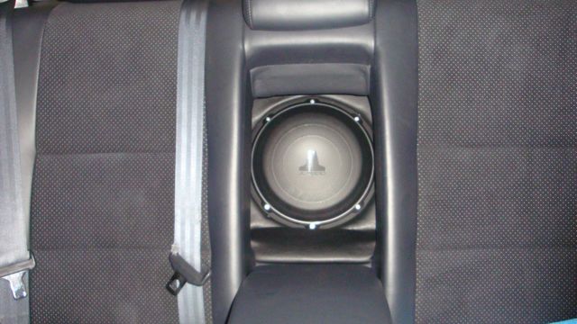 JL Audio subwoofer mounted in a center console behind cloth seats