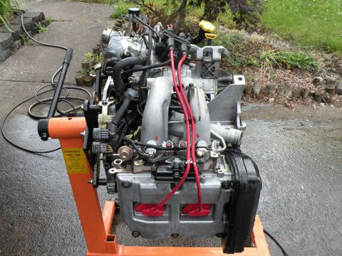 1998 Subaru Legacy - Engine assembly displayed on an orange engine stand, ready for installation or repair.