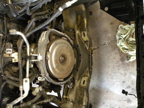 1998 Subaru Legacy - Close-up view of a vehicle's engine bay, focusing on the transmission torque converter and surrounding components.