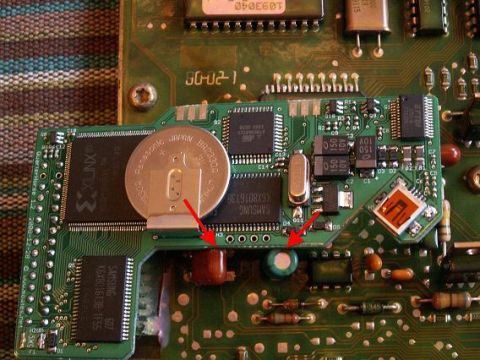 1996 Ford Bronco - This image shows a close-up view of electronic components on a circuit board, including a Panasonic coin cell battery and several integrate…