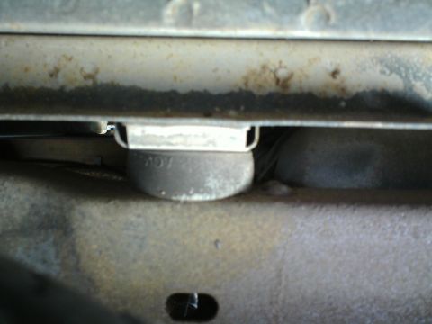 1990 Ford Bronco - A close-up of a vehicle's undercarriage reveals a component with "ROY" stamped on it, indicating wear and tear.