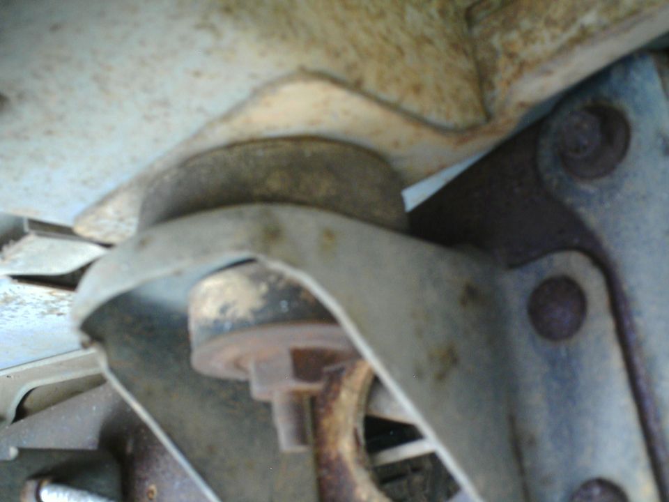 Close-up of a vehicle's suspension mount with visible rust