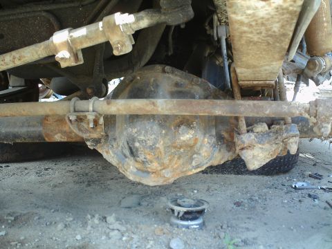 1990 Ford Bronco - Close-up view of the undercarriage, focusing on the differential and suspension system of a vehicle.
