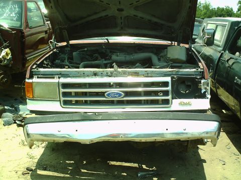 1990 Ford Bronco - Front view of a Ford truck with its hood open, parked next to another vehicle.