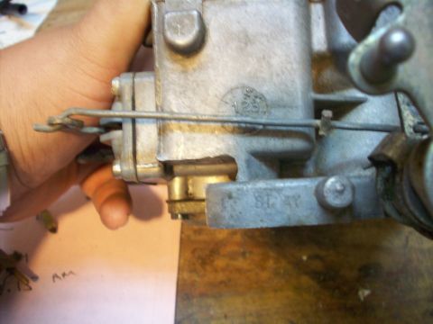 1978 Jeep CJ5 - A close-up view of a carburetor part, showing stamped markings and a circular emblem.