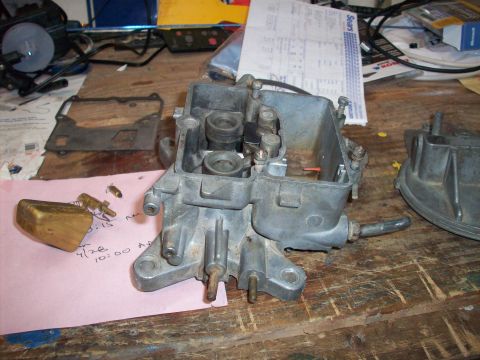 1978 Jeep CJ5 - A disassembled carburetor sits on a workbench next to a pink note with handwritten dates and times.