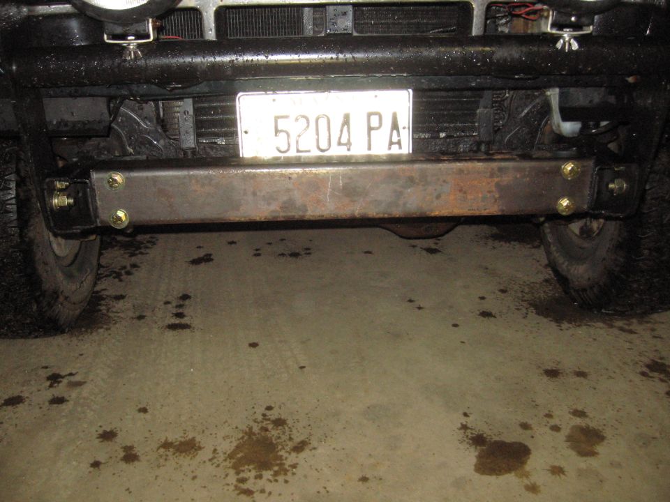 Rusty steel hitch bar bolted across truck frame under Maine plate 5204 PA in garage