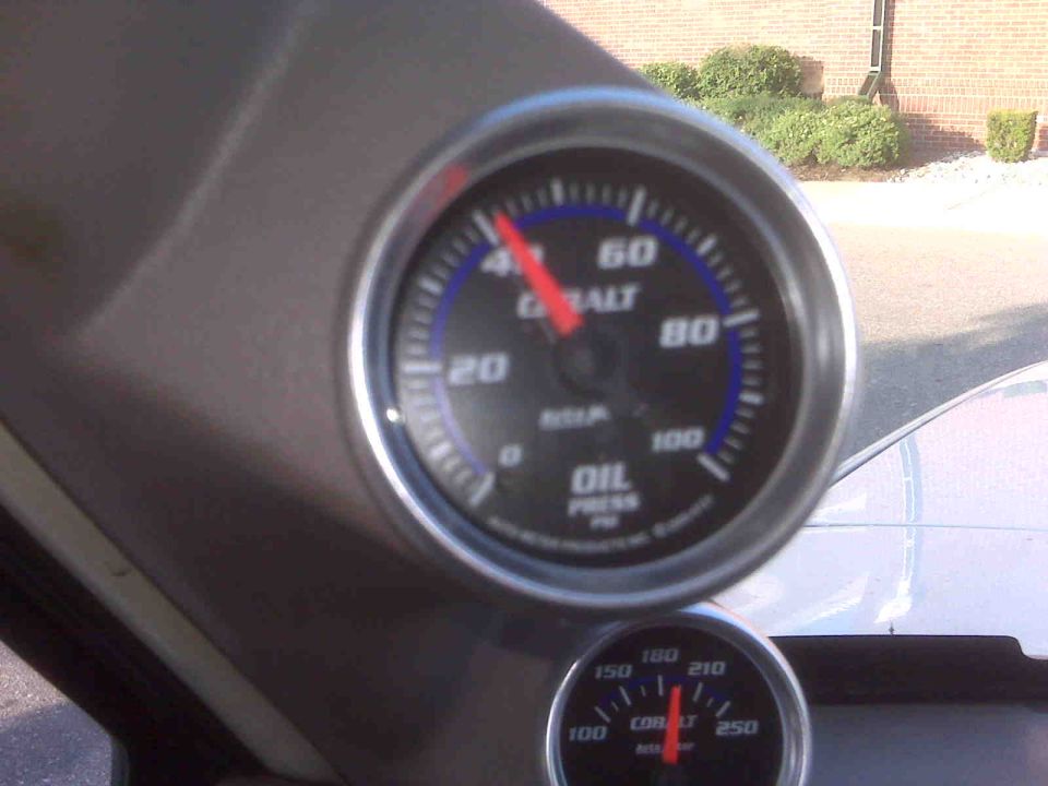 Cobalt oil pressure gauge showing 40 PSI, with a smaller temperature gauge below. Part of a vehicle interior is visible