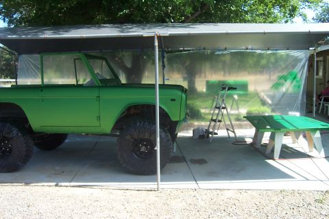 1976 Ford Bronco - Green 1976 Ford Bronco parked under a canopy, possibly being prepped for paint.