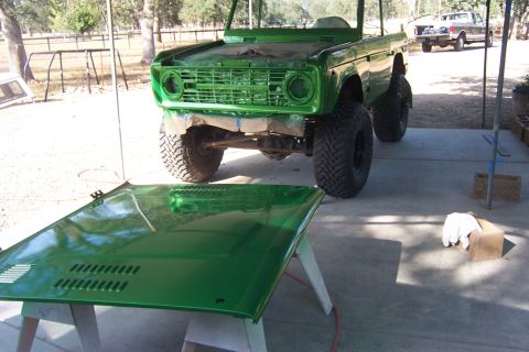 1976 Ford Bronco - A freshly painted green Ford Bronco is shown with its hood removed, sitting outside next to a second vehicle.