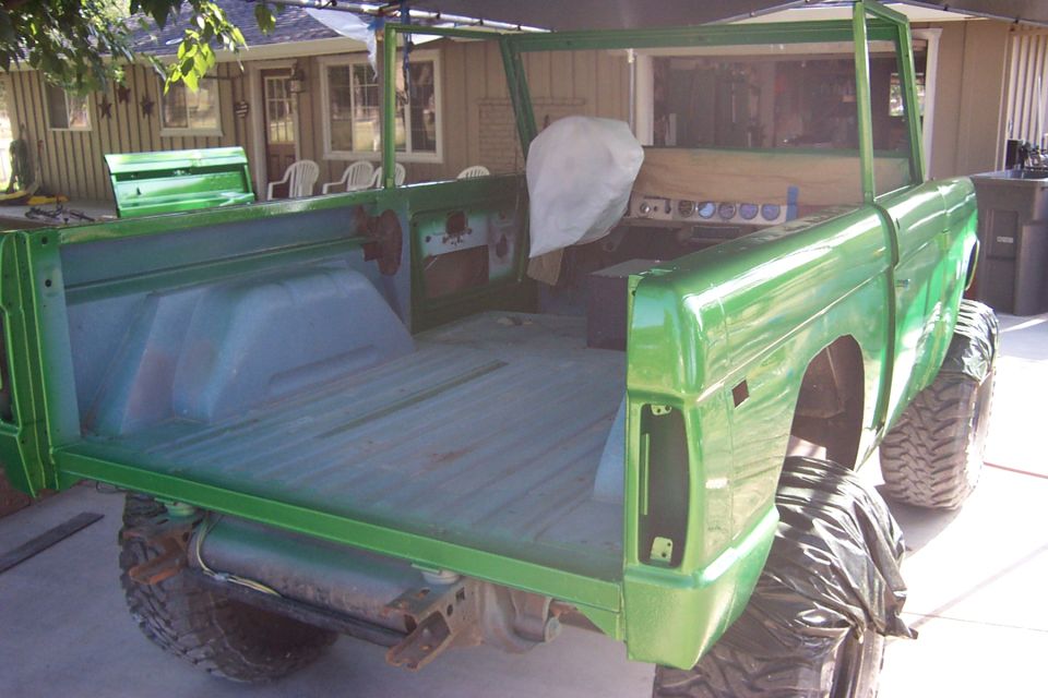 Green 1976 Ford Bronco body, rear view, undergoing restoration