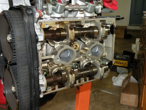 1998 Subaru Legacy - Close-up view of an engine's internal components, including camshafts and a timing belt, with some garage items in the background.