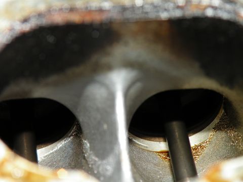1998 Subaru Legacy - This image shows the interior of an engine cylinder head, focusing on the valves and the surrounding metal.