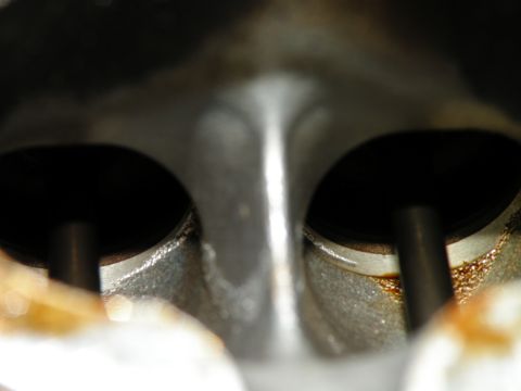 1998 Subaru Legacy - Close-up view of an engine cylinder head, showing two valves and signs of wear.