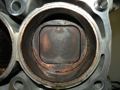 1998 Subaru Legacy - Engine cylinder bore with piston top visible, showing significant carbon deposits.