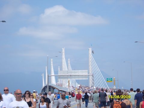 1989 Ford Bronco - A large crowd walks across a modern suspension bridge on a sunny day.