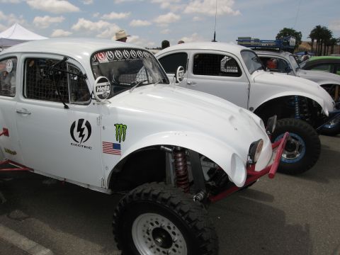 1986 Ford Bronco - Two white off-road Volkswagen Beetles are parked side-by-side, one with prominent racing decals.