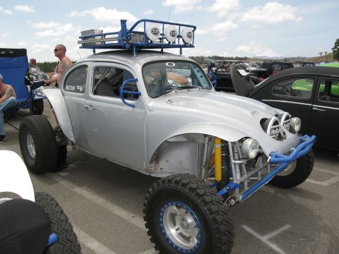 1986 Ford Bronco - Modified Volkswagen Beetle with off-road tires and roof rack, parked next to another Beetle.