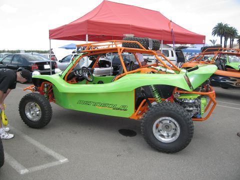 1986 Ford Bronco - A custom dune buggy with a bright green body and orange frame is parked outdoors.