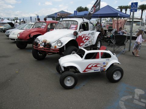 1986 Ford Bronco - A line of custom Volkswagen Beetles, including a full-size dune buggy and a smaller version, are displayed outdoors.