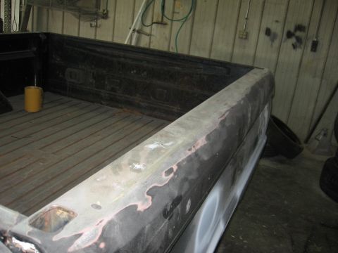 1966 Ford F-100 - The side of a truck bed, showing primer and some bodywork, is viewed from a high angle.