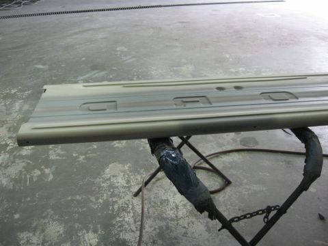 1966 Ford F-100 - Truck door panel undergoing body shop work, supported by a metal stand.