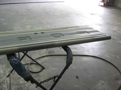 1966 Ford F-100 - A truck tailgate is shown on a stand in what appears to be a workshop or garage.