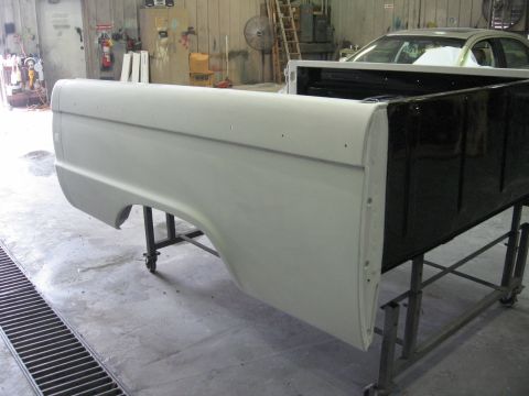 1966 Ford F-100 - A truck bed side panel is prepped for paint in a body shop.